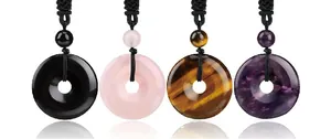 Detailed view of donut gemstone pendants in obsidian, rose quartz, and tiger eye with cord