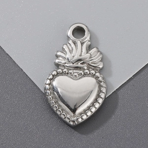 Close-up of heart-shaped stainless steel pendant with crown detail and beaded edges