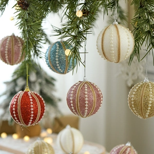 Glittery 8cm Christmas foam balls with pearls and twine hanging on a festive tree