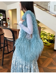 Blue faux fur hobo bag with long plush texture shown in a lifestyle indoor setting