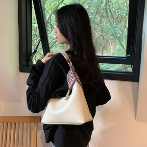 Minimalist white leather hobo underarm bag with a decorative geometric silk scarf