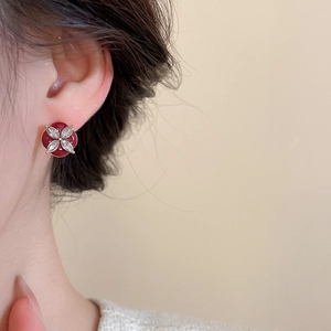 Close-up of red flower stud earrings with marquise-cut zircon worn by a model