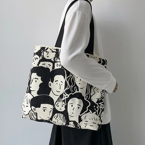 Side view of large canvas tote bag with artistic face print worn by a female model