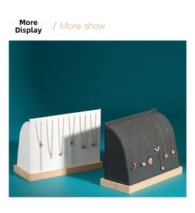 Detail view of arched necklace display stand with premium wood base and leather padding