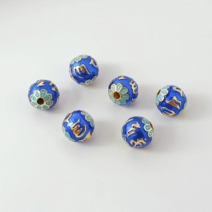 Macro view of six royal blue cloisonné enamel watermelon beads with gold floral patterns