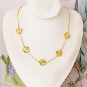 Golden necklace with five sunburst texture flower pendants displayed on jewelry bust