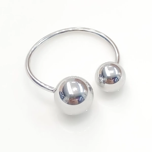 Close-up of a polished silver titanium steel open bangle with smooth spherical ends