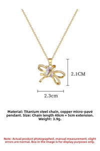 Macro detail of gold-plated titanium steel necklace with micro-paved bow pendant