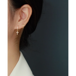 Detail of gold cross hoop earrings with sparkling diamonds on a model for a luxe look