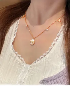 Vue détaillée du collier ovale en nacre plaqué or 18 carats porté par un mannequin