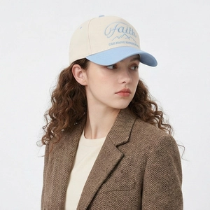 Cotton baseball cap with Faith embroidery in beige and blue, worn by a model