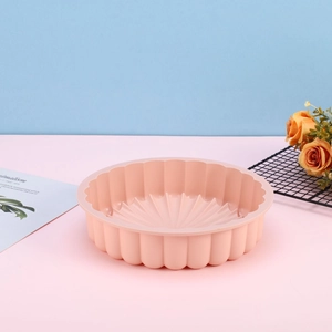 Pink silicone sunflower cake mold with wave edges on a stylish blue and pink background