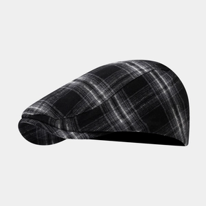 Detailed close-up of British style black and grey plaid newsboy cap in tweed fabric
