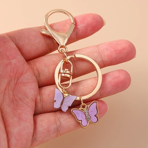 Golden keychain featuring sparkling purple rhinestone butterfly pendants on a ring clasp