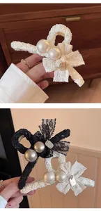 Vue détaillée de la pince à cheveux en dentelle élégante avec perles et nœud décoratif