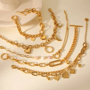 Detailed view of gold pearl bracelets with heart charms and OT toggle clasp closure