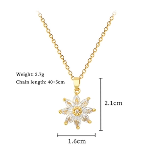 Macro detail of gold flower pendant with crystal pavé, showing dimensions and weight