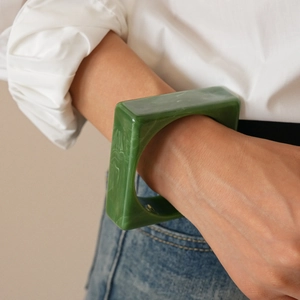 Chunky green marble resin square bangle shown on model with minimalist fashion styling