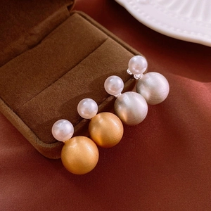 Vintage geometric faux pearl earrings with gold and silver matte finish on silk backdrop