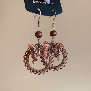 Vintage wooden bead butterfly pendant earrings with geometric circular design in retro ethnic style