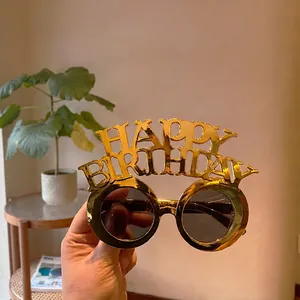 Detailed close-up of golden Happy Birthday party glasses with circular dark lenses
