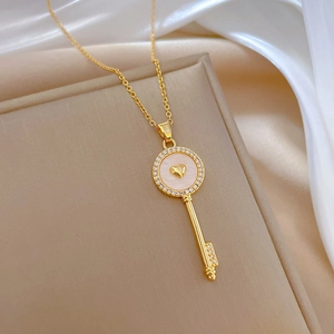 Close-up of a gold key pendant with a heart inlay and crystal accents on a silk background