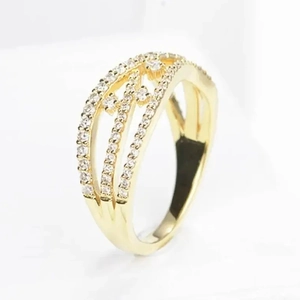 Detalle macro de un anillo dorado calado con brillantes piedras de circonita