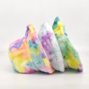 Three colorful tie-dye faux fur bucket hats stacked showing soft plush texture