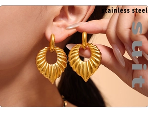 Detailed view of gold stainless steel shell earrings with wavy texture and hollow holes