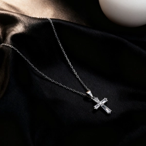 Silver stainless steel cross necklace with cubic zirconia on black silk background