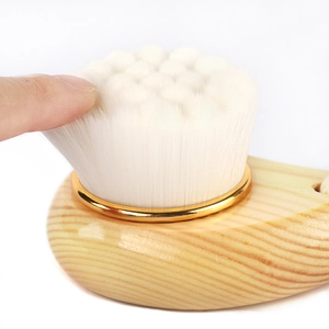 Manual facial cleansing brush with natural wood handle and soft fiber bristles