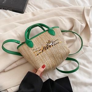 Green straw basket bag with tiger embroidery and PU leather handles on beige blazer