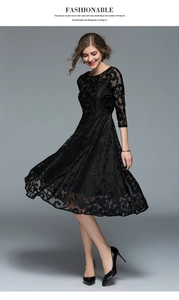 Detail of black lace midi dress featuring intricate floral patterns and A-line silhouette