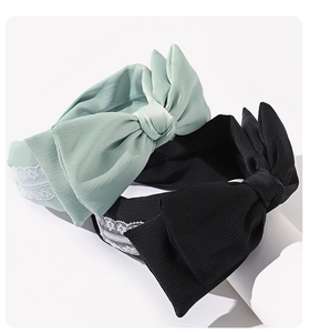 Detail of mint green and black fabric headbands with large bows and white lace trim
