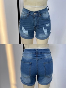 Front and back detail of distressed blue denim shorts with rolled cuffs and ripped texture