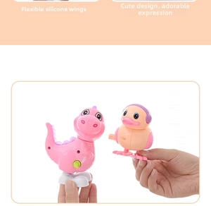 Détail de jouets à remonter montrant un dinosaure rose et un canard aux ailes en silicone