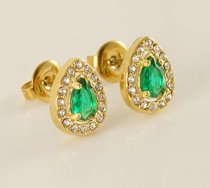 Macro shot of gold-plated teardrop earrings with green pear-cut crystal and zirconia details