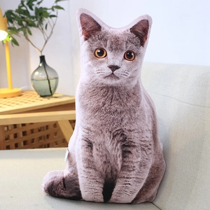 Lifelike gray tabby cat plush pillow on a beige sofa in a modern home setting