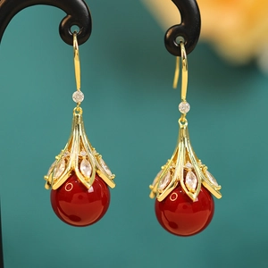 Detail of red bead earrings with golden floral caps and inlaid marquise zircons