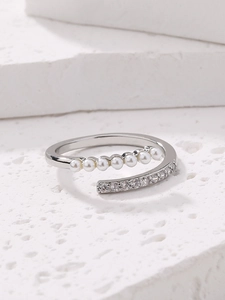 Detailed shot of adjustable silver ring with micro-set pearls and zircons on white stone