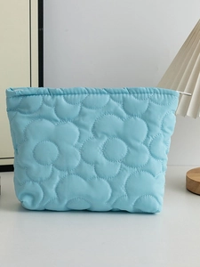 Borsa cosmetica trapuntata azzurra con fiori per prodotti di bellezza e uso da viaggio