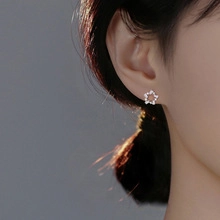 Close-up of star-shaped silver stud earrings with shimmering pave-set cubic zirconia