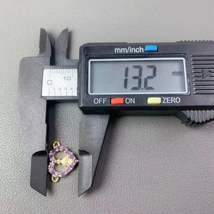 Macro shot showing 13.2 mm width measurement of golden heart Virgin Mary pendant