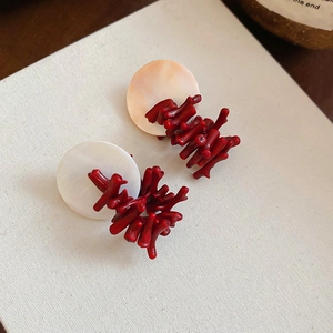 Detail of red coral resin branches on round shell discs vintage stud earrings for women