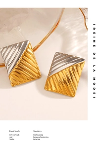 Detailed close-up of rectangular bicolor gold and silver earrings with textured stripes
