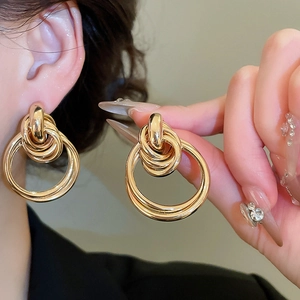 Gros plan de boucles d'oreilles circulaires dorées polies montrant l'éclat du métal