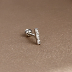 Macro detail of silver stainless steel stud featuring five clear zircon stones