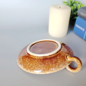 Modern brown ceramic candle holder with glazed texture, bottom view of a sleek saucer