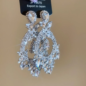 Macro view of silver teardrop earrings with crystals and sparkling stone details