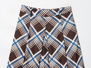 Gros plan d'une jupe à carreaux marron et bleu avec boucle de taille et plis